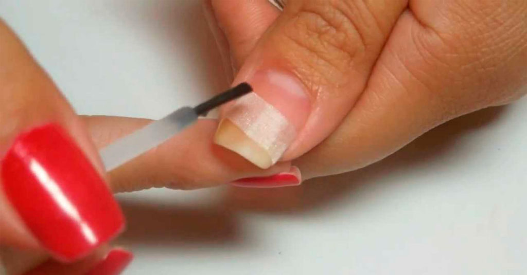 Manicura reparando una uña partida en la esquina