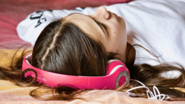 estudante se duerme con los auriculares