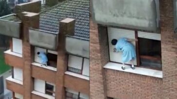 limpia las persianas sobre el alféizar de la ventana en un séptimo piso sin sujeción