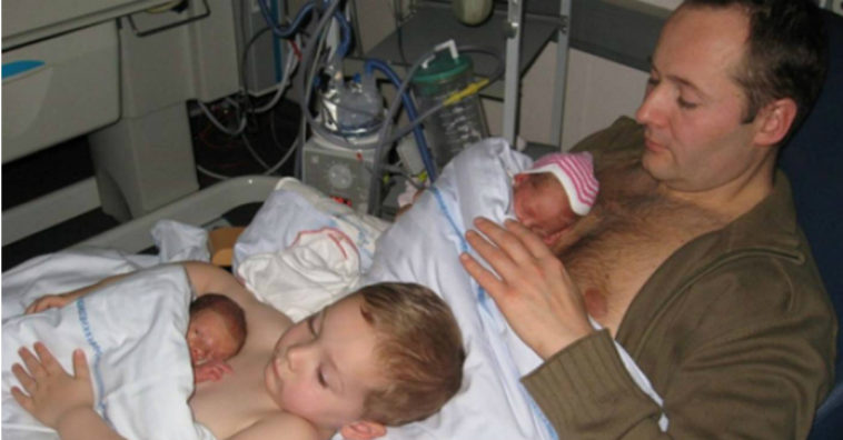 padre e hijo fotografiados calentando a los gemelos recién nacidos